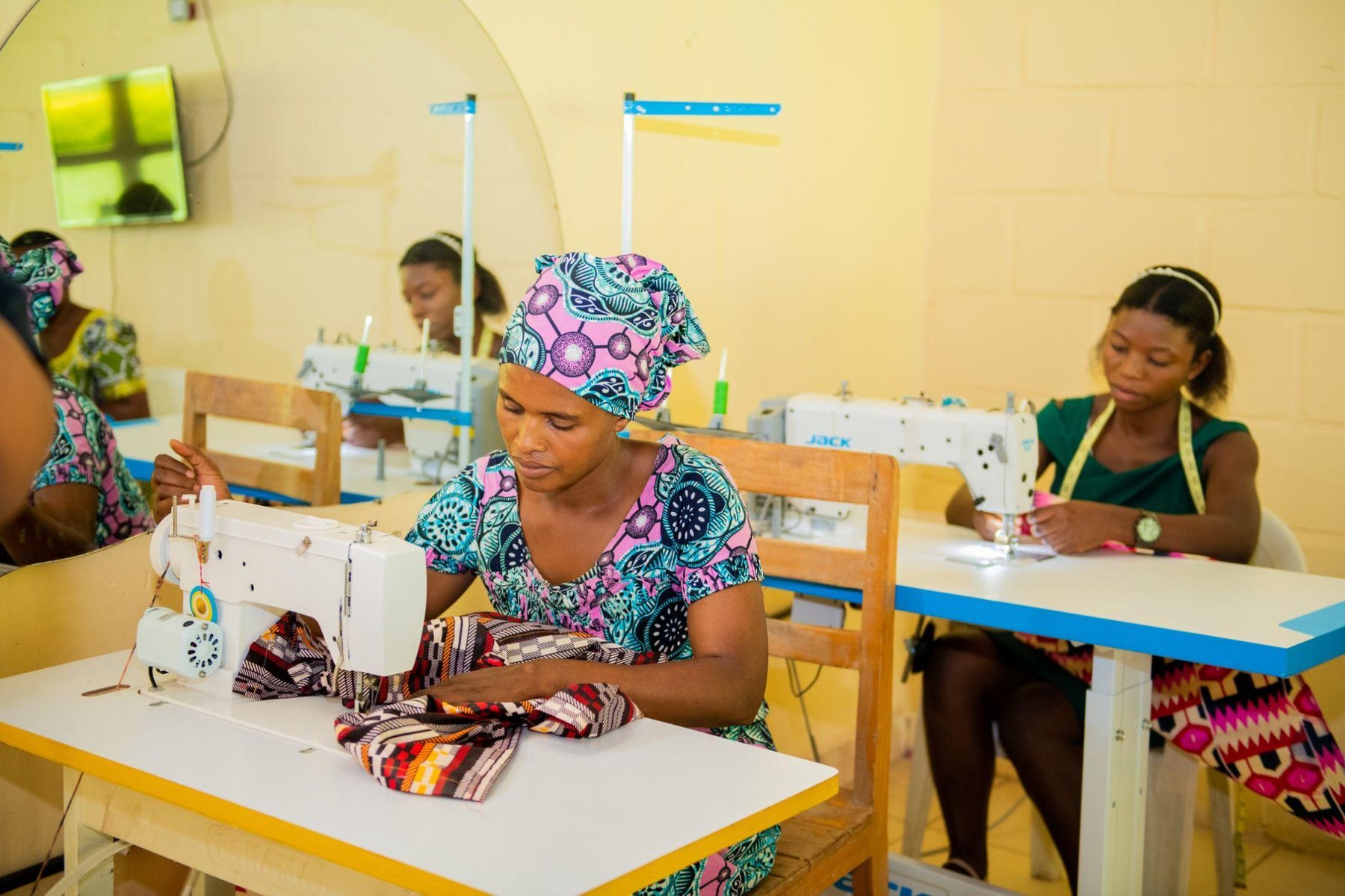 Mothers in the Feed My Sheep tailoring class, learning on sewing machines